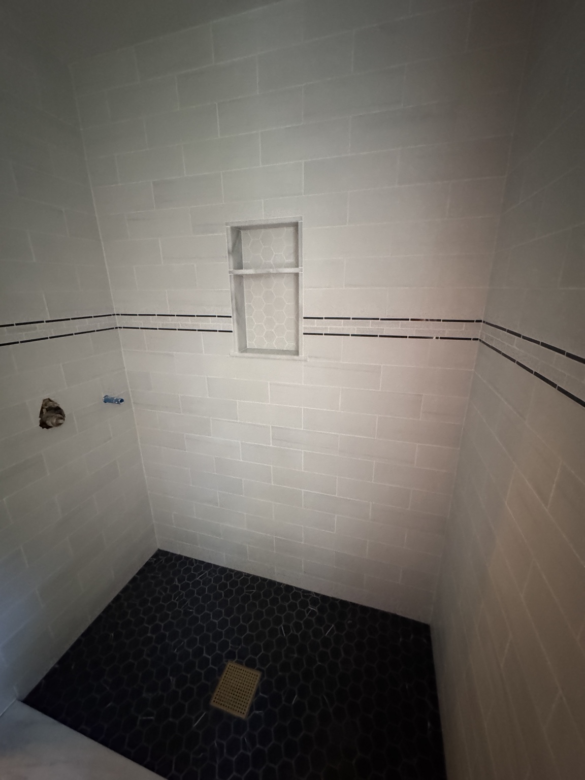 Custom tiled walk-in shower with inset storage niche